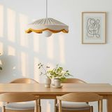 A natural and mustard scallop shade hanging over a dining table