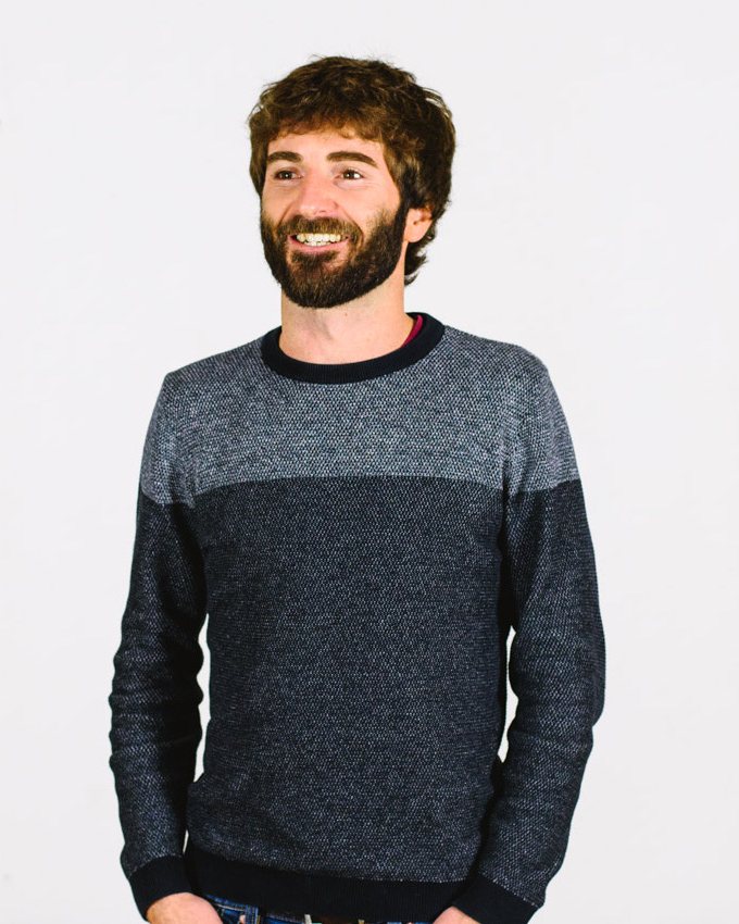 Hayden, who builds Pip, smiling, in a grey knitted jumper